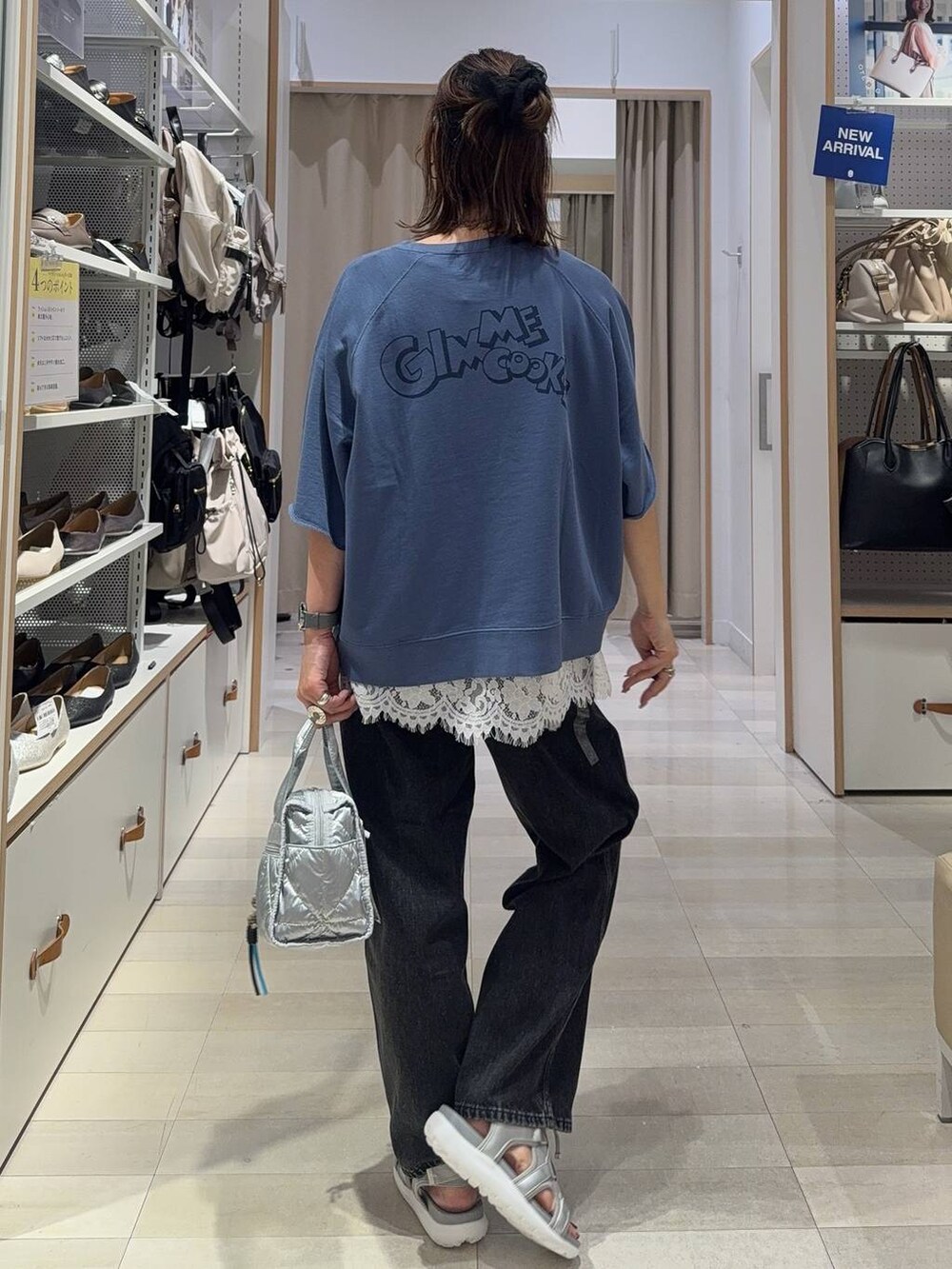 ブラック系のサンダル、ブラック系のTシャツ/カットソー、ブルー系のデニムパンツを着用したレディースの夏コーディネートの6枚目の写真