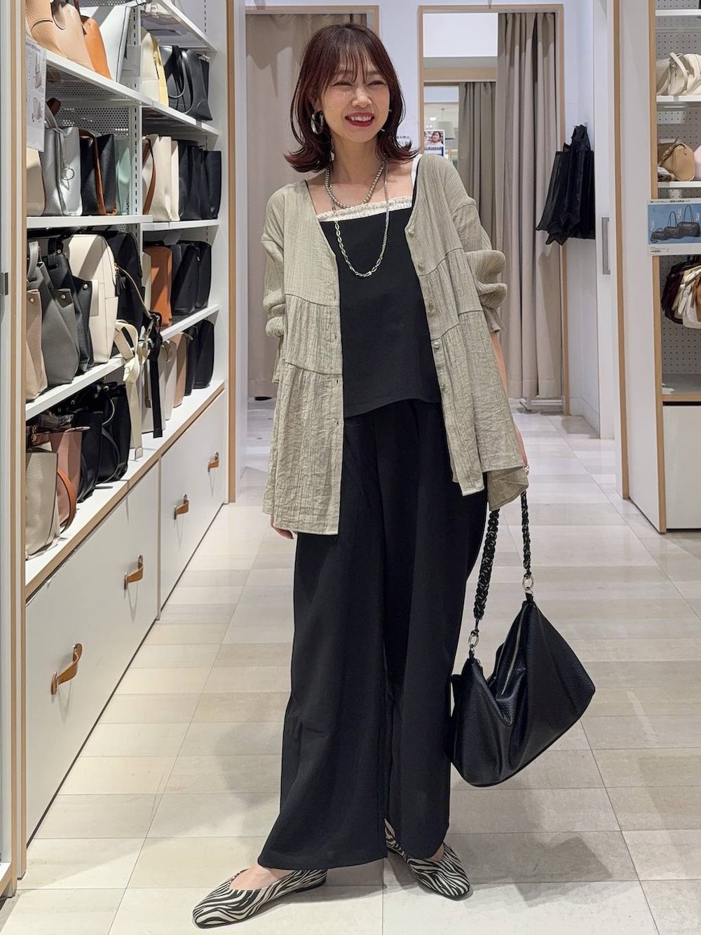 ブラック系のパンプス、ブルー系のデニムパンツ、ホワイト系のスウェットを着用したレディースの春コーディネートの8枚目の写真