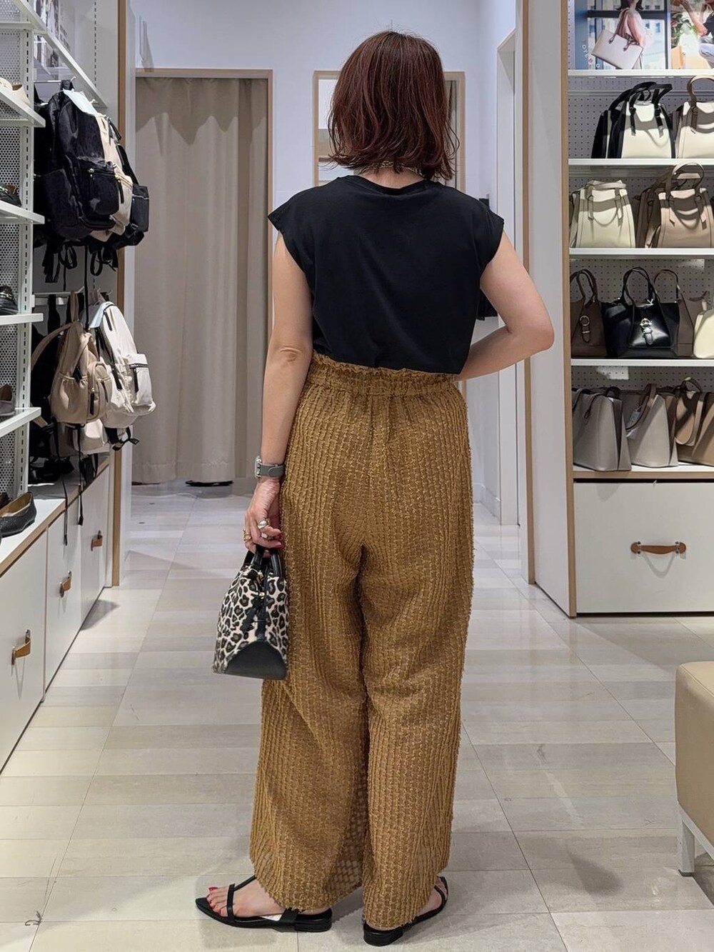 ブルー系のデニムパンツ、ブラック系のバックパック/リュック、ホワイト系のTシャツ/カットソーを着用したレディースの夏コーディネートの9枚目の写真