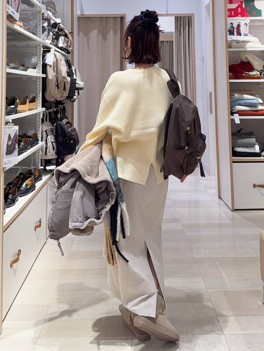 ブラウン系のブルゾン、グレー系のスカート、イエロー系のニット/セーターを着用したレディースの冬コーディネートの8枚目の写真