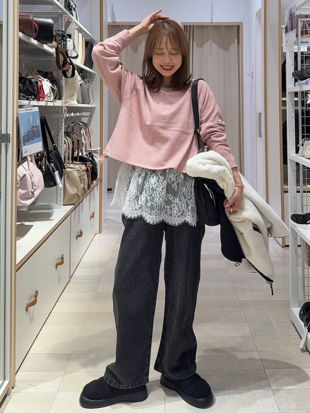 ホワイト系のTシャツ/カットソー、ブラック系のショルダーバッグ、ブラック系のデニムパンツを着用したレディースの秋コーディネートの3枚目の写真