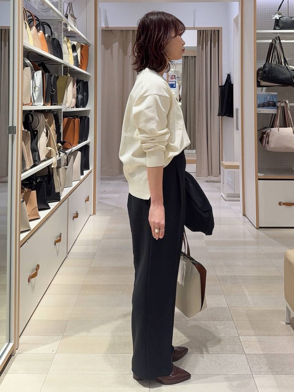 ブラック系のその他パンツ、ブラック系のテーラードジャケット、ホワイト系のトートバッグを着用したレディースの春コーディネートの7枚目の写真