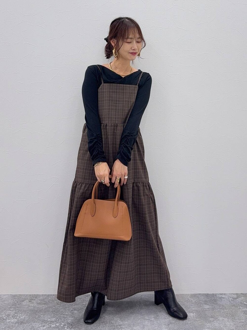 ブラウン系のショルダーバッグ、ブラック系のブーツ、ホワイト系のシャツ/ブラウスを着用したレディースの秋コーディネートの2枚目の写真