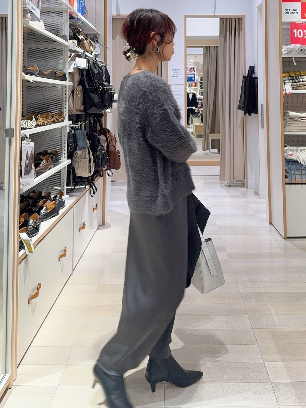 シルバー系のショルダーバッグ、ベージュ系のダウンジャケット/コート、グレー系のニット/セーターを着用したレディースの冬コーディネートの8枚目の写真