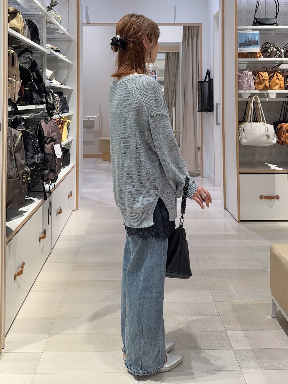 ブルー系のデニムパンツ、ブラック系のキャミソール、ブルー系のカーディガン/ボレロを着用したレディースの春コーディネートの5枚目の写真