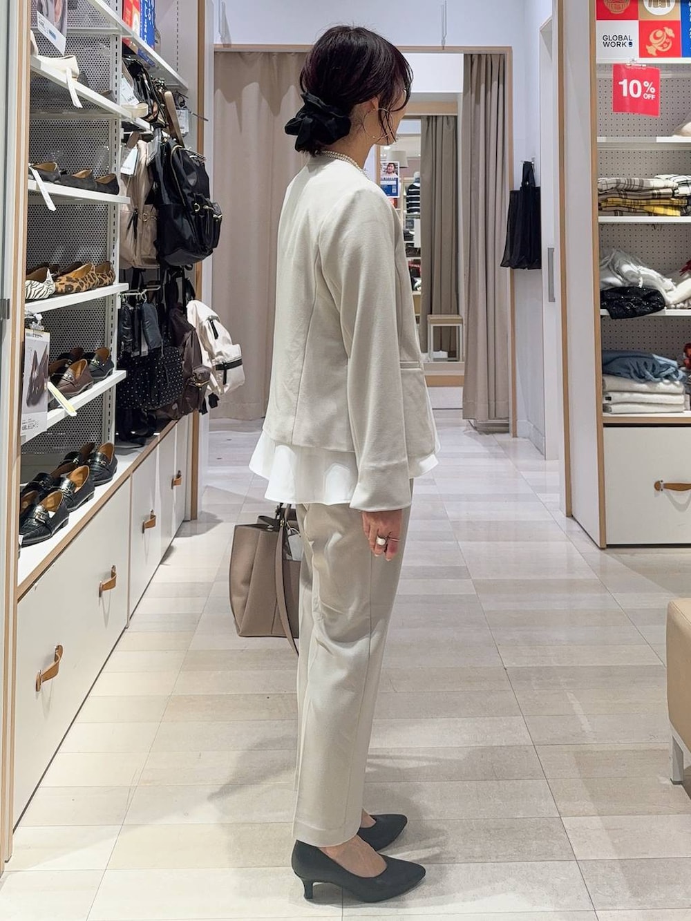 ブラック系のパンプス、ベージュ系のパンツドレス、ベージュ系のトートバッグを着用したレディースの冬コーディネートの4枚目の写真