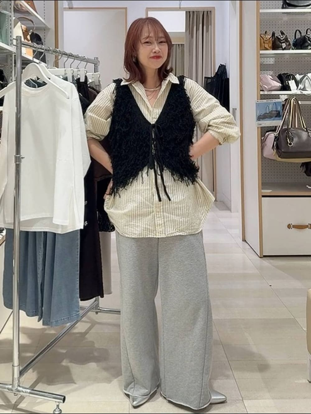 ホワイト系のTシャツ/カットソー、ブラック系のベスト、ブルー系のデニムパンツを着用したレディースの春コーディネートの2枚目の写真