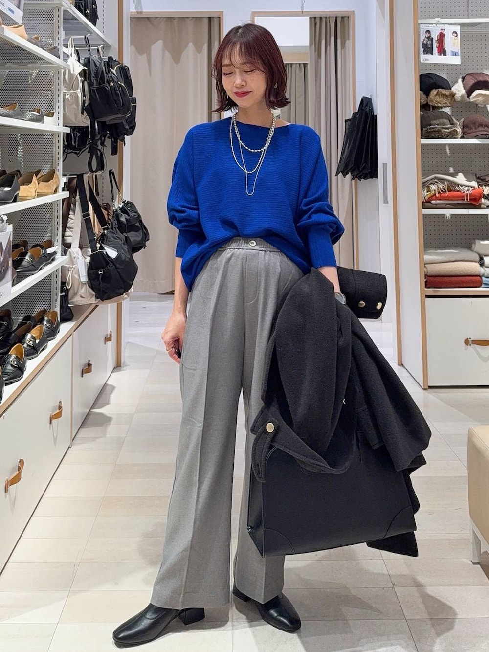 ブラック系のローファー、ホワイト系のTシャツ/カットソー、ブルー系のニット/セーターを着用したレディースの冬コーディネートの2枚目の写真