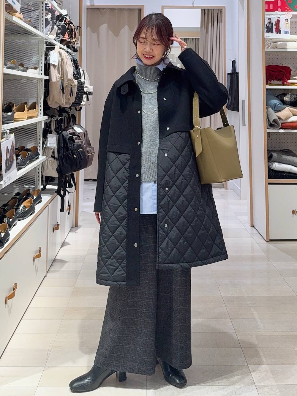 グリーン系のショルダーバッグ、ブラック系のステンカラーコート、ブルー系のシャツ/ブラウスを着用したレディースの冬コーディネートの2枚目の写真