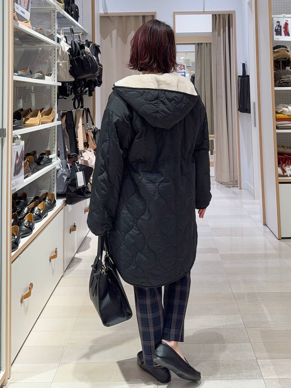 ブラック系のショルダーバッグ、ブラック系のブルゾン、ホワイト系のニット/セーターを着用したレディースの冬コーディネートの4枚目の写真