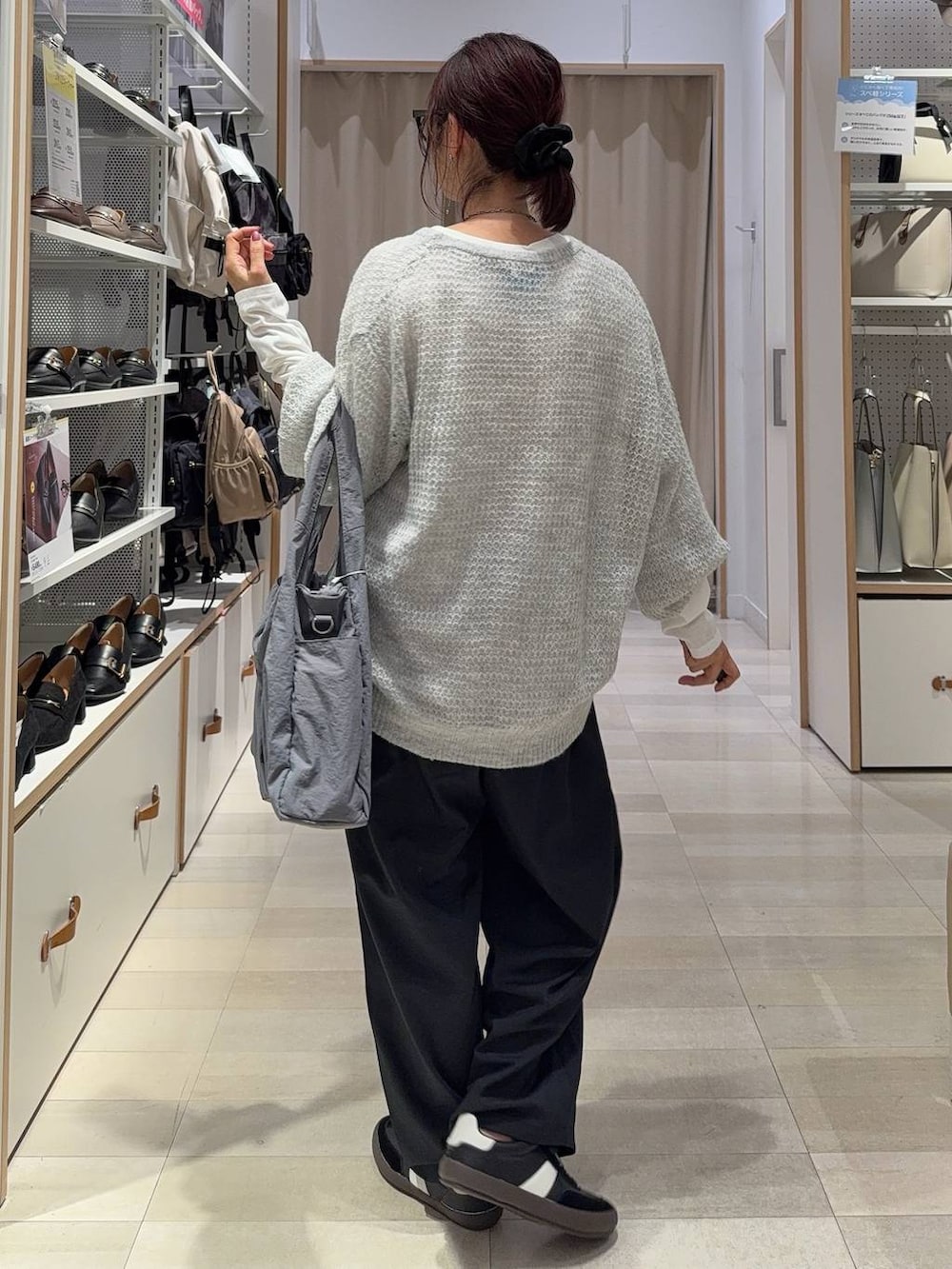 ブラック系のスニーカー、グレー系のトートバッグ、グレー系のニット/セーターを着用したレディースの秋コーディネートの3枚目の写真