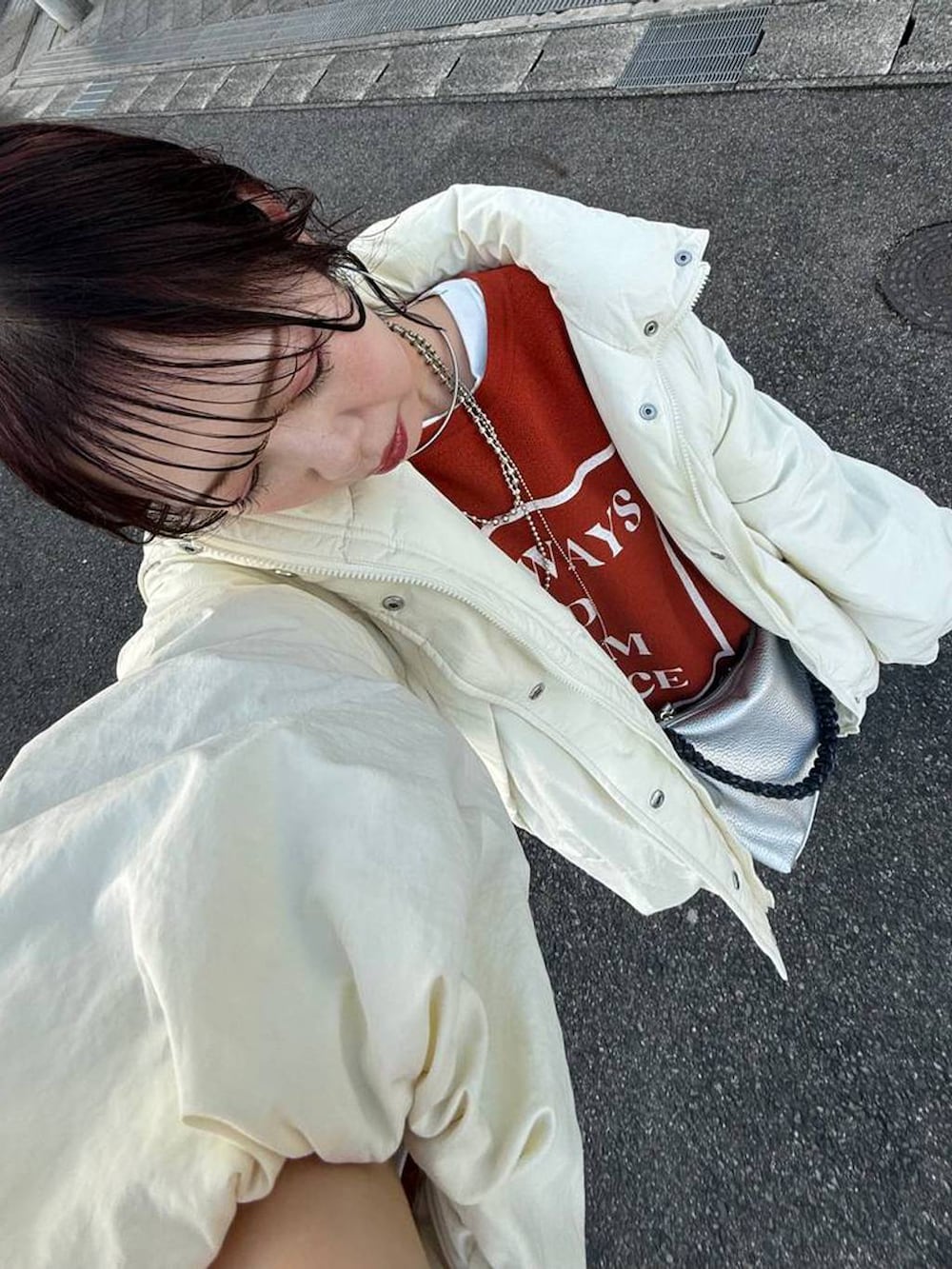 ホワイト系のTシャツ/カットソー、グレー系のスカート、シルバー系のネックレスを着用したレディースの冬コーディネートの2枚目の写真