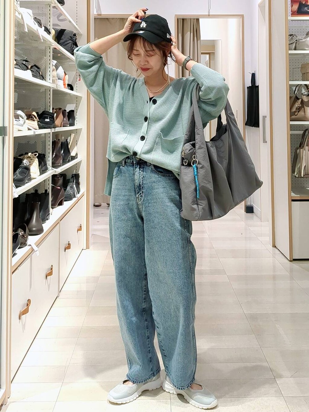 ブラック系のショルダーバッグ、グリーン系のカーディガン/ボレロ、グレー系のスカートを着用したレディースの春コーディネートの4枚目の写真