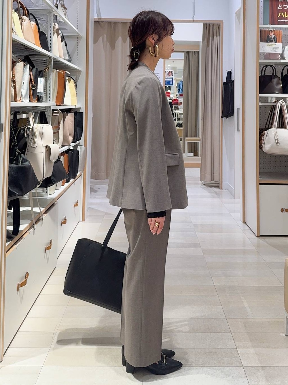 ブラウン系のスラックス、ブラック系のTシャツ/カットソー、ブラック系のトートバッグを着用したレディースの冬コーディネートの6枚目の写真