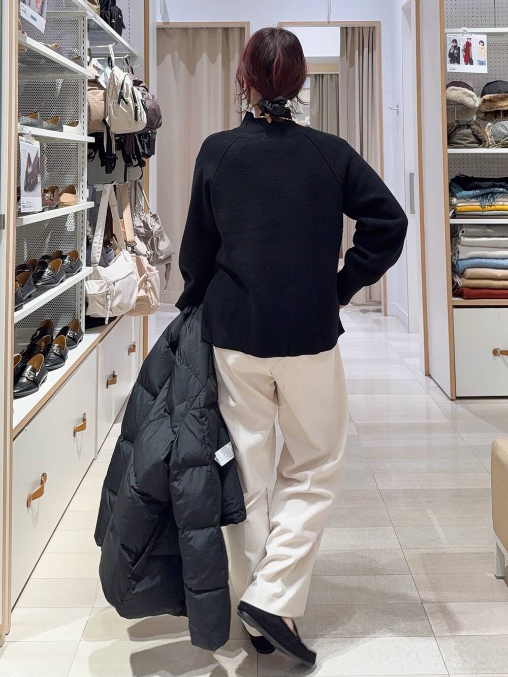 ブラック系のダウンジャケット/コート、グリーン系のショルダーバッグ、ブラック系のニット/セーターを着用したレディースの秋コーディネートの9枚目の写真