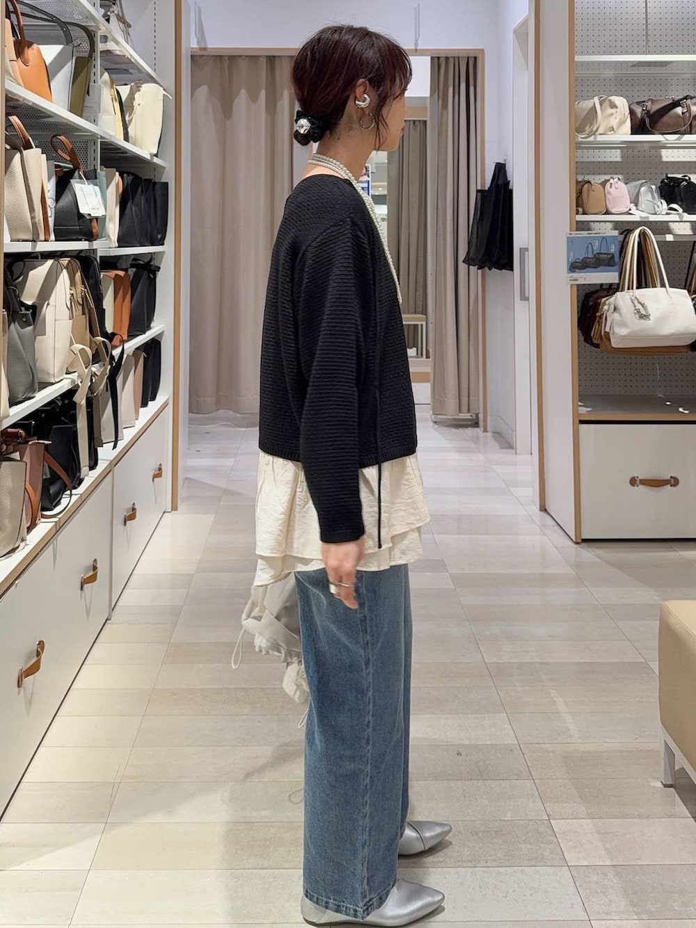 ホワイト系のパンプス、ブルー系のデニムパンツ、ベージュ系のマウンテンパーカーを着用したレディースの春コーディネートの5枚目の写真