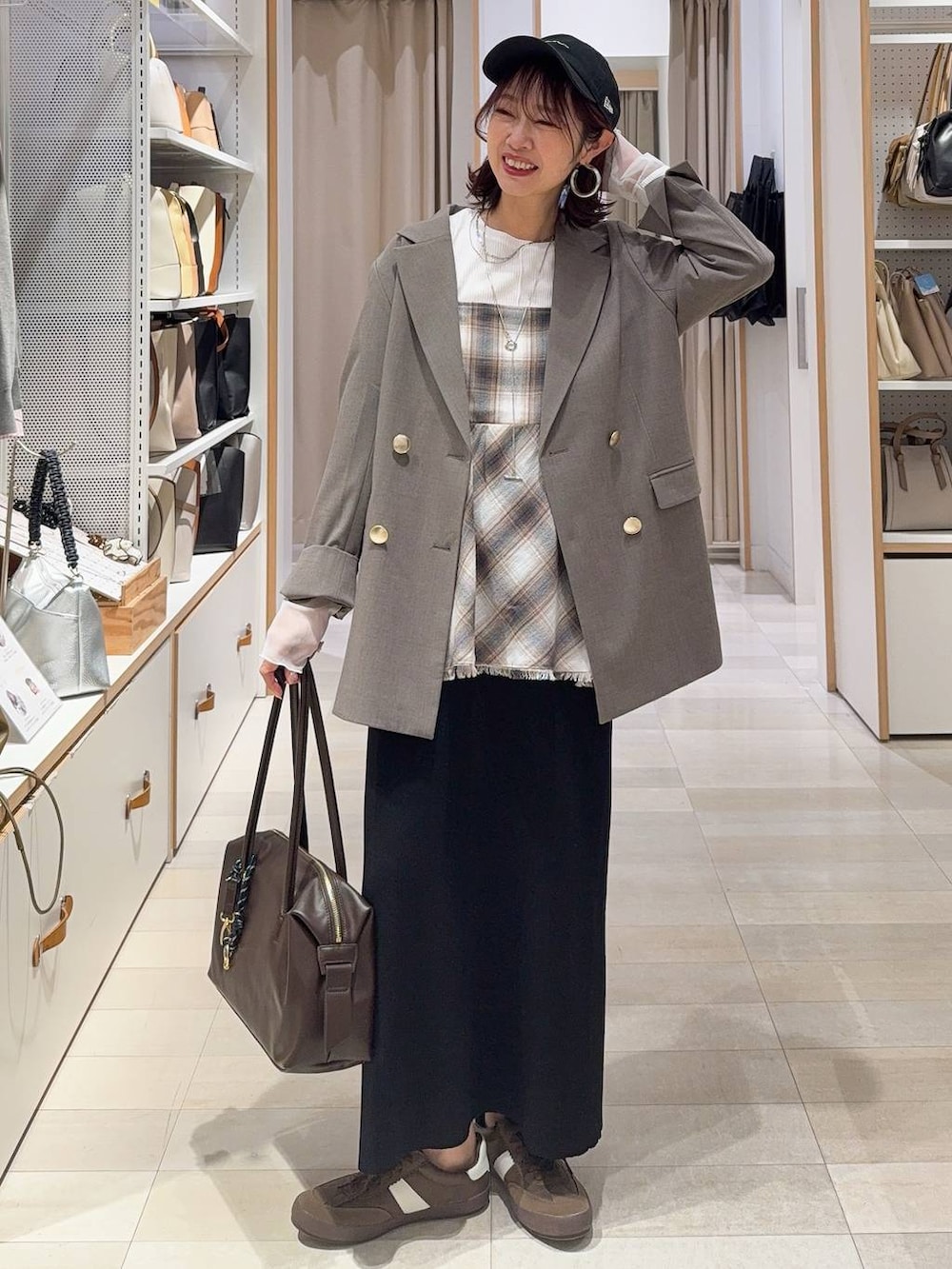 ホワイト系のキャミソール、ホワイト系のTシャツ/カットソー、ブラウン系のスラックスを着用したレディースの冬コーディネートの4枚目の写真