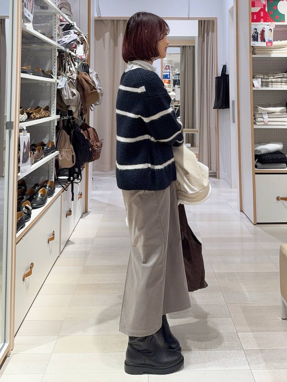 ブラウン系のスカート、ブラウン系のトートバッグ、ホワイト系のTシャツ/カットソーを着用したレディースの冬コーディネートの6枚目の写真