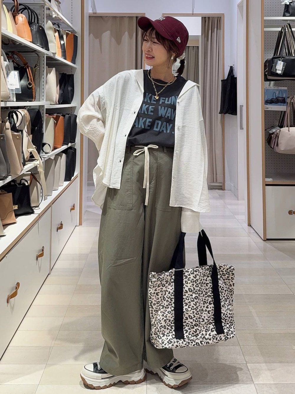 ブラック系のパンプス、ブラウン系のその他パンツ、ホワイト系のタンクトップを着用したレディースの春コーディネートの2枚目の写真