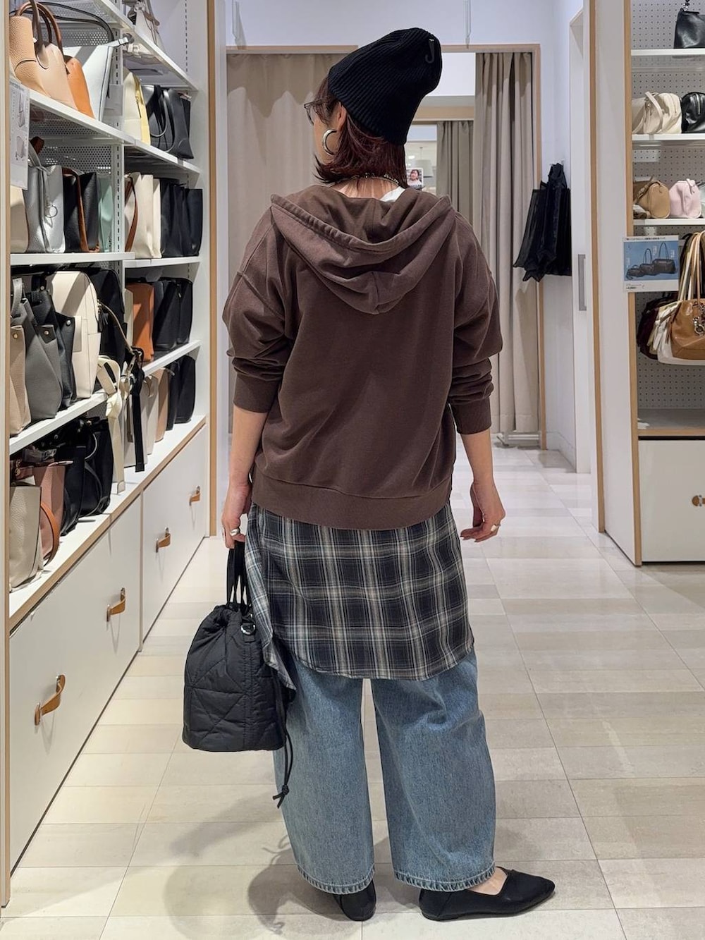 ブラック系のパンプス、ブラック系のハンドバッグ、ブルー系のデニムパンツを着用したレディースの春コーディネートの6枚目の写真