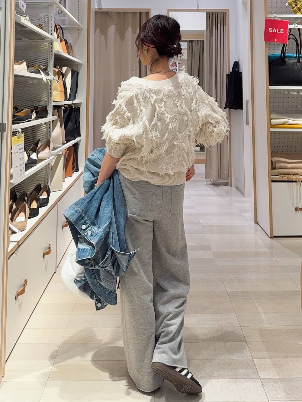 ブラック系のキャミソール、ホワイト系のハンドバッグ、ブルー系のデニムジャケットを着用したレディースの冬コーディネートの6枚目の写真