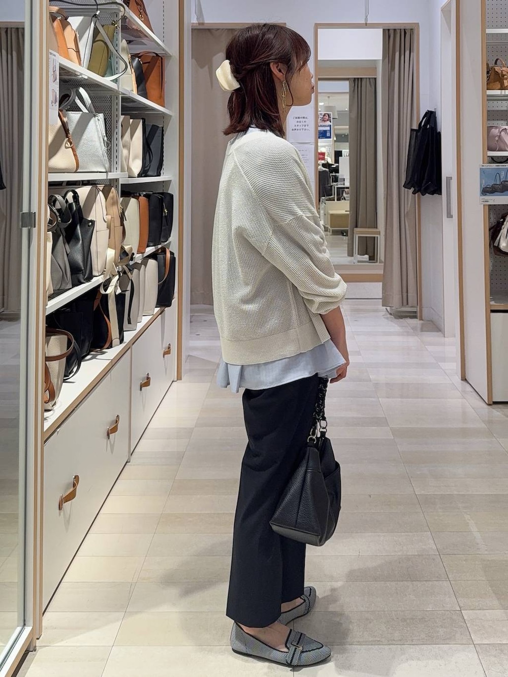 ブラック系のパンプス、ブルー系のスラックス、ホワイト系のカーディガン/ボレロを着用したレディースの春コーディネートの4枚目の写真