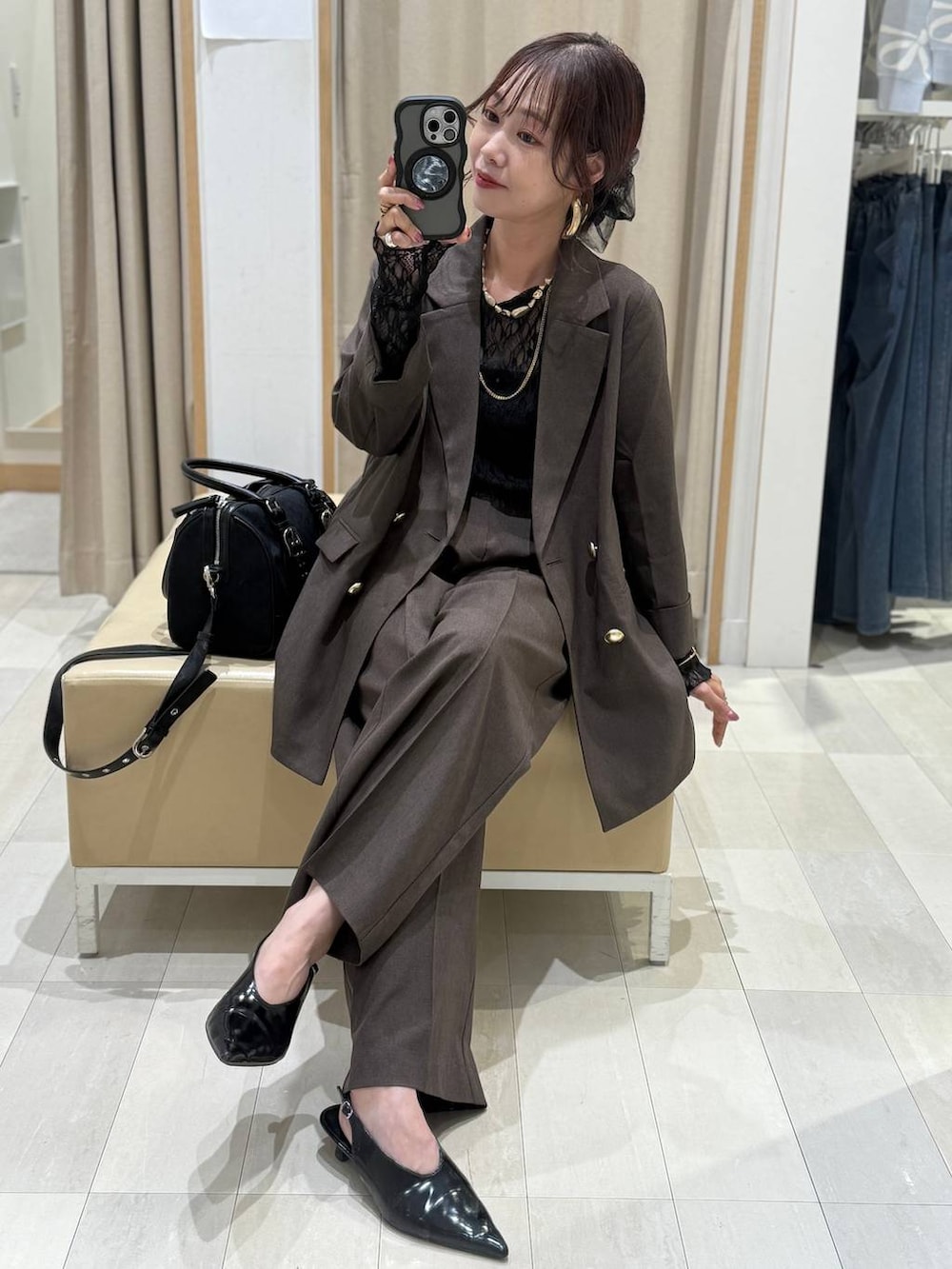 ブラック系のキャミソール、ブラウン系のテーラードジャケット、ブラウン系のスラックスを着用したレディースの秋コーディネートの2枚目の写真