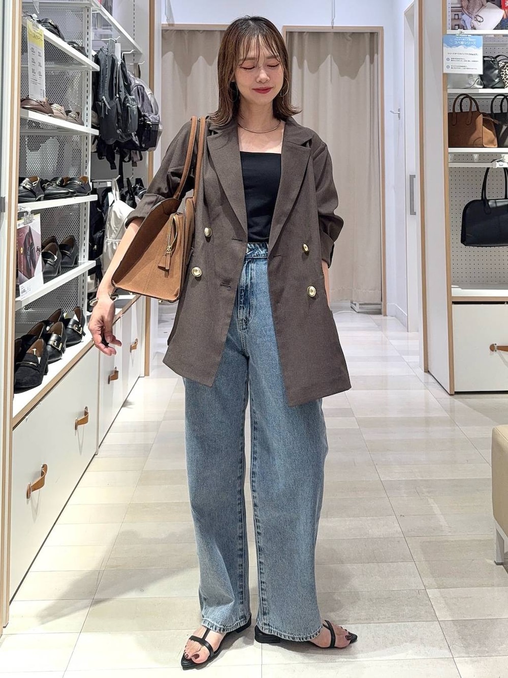 ブラック系のキャミソール、ブラウン系のテーラードジャケット、ブラウン系のスラックスを着用したレディースの秋コーディネートの7枚目の写真