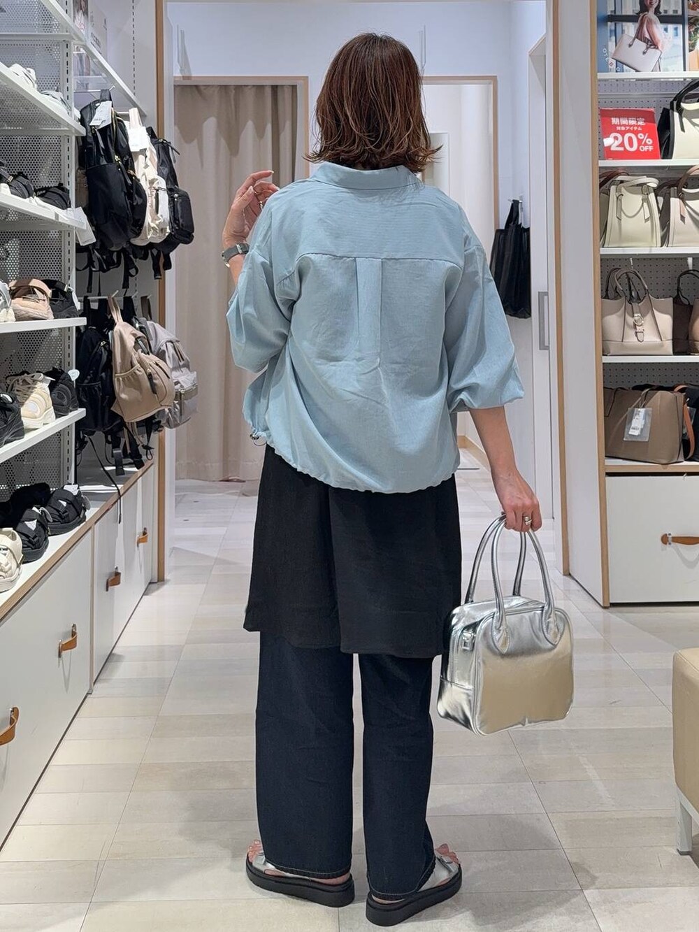 ブルー系のデニムパンツ、グレー系のボストンバッグ、ブルー系のシャツ/ブラウスを着用したレディースの春コーディネートの4枚目の写真