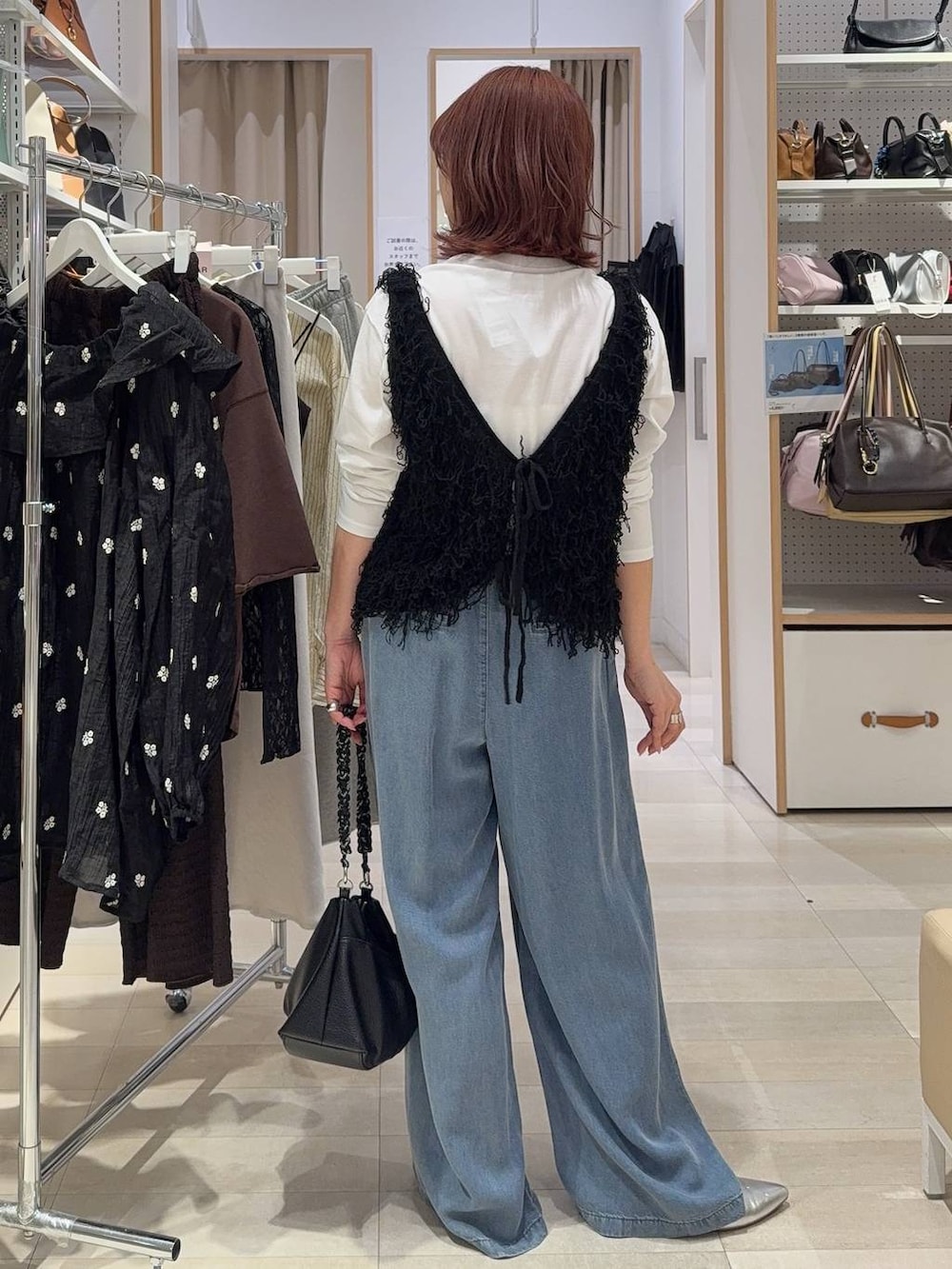 ホワイト系のTシャツ/カットソー、ブラック系のベスト、ブルー系のデニムパンツを着用したレディースの春コーディネートの6枚目の写真