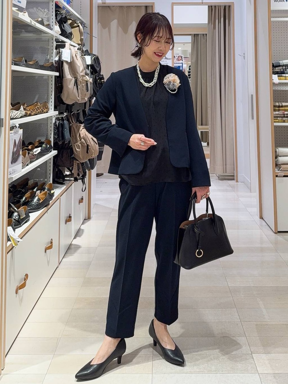 ブラック系のショルダーバッグ、ブラック系のパンプス、ブルー系のセットアップを着用したレディースの冬コーディネートの3枚目の写真