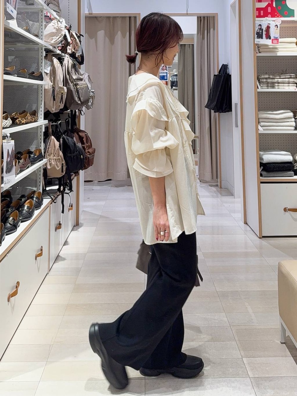 ブラウン系のボストンバッグ、ブラック系のブーツ、ブラウン系のカーディガン/ボレロを着用したレディースの冬コーディネートの7枚目の写真