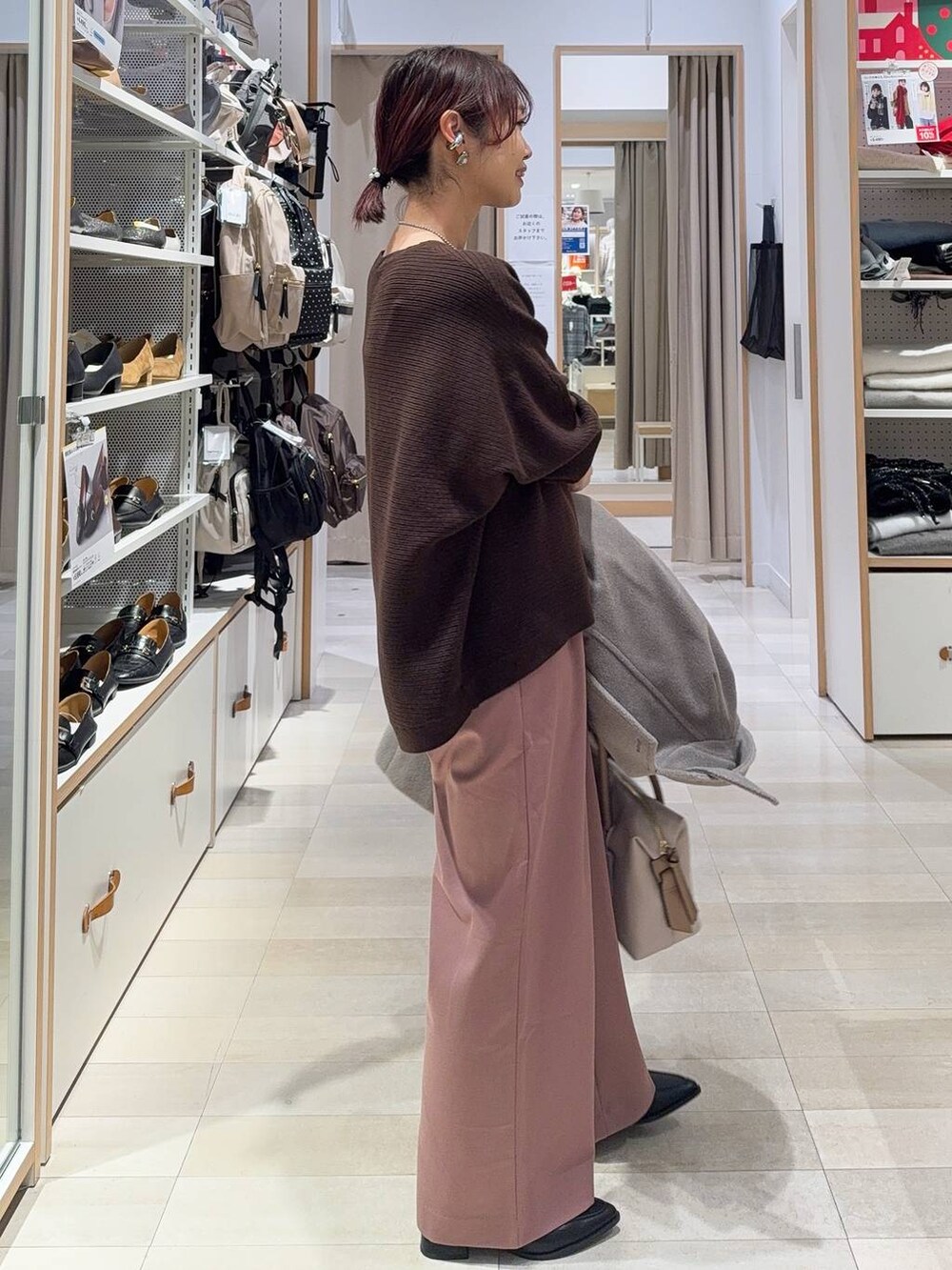 ブラック系のボストンバッグ、ベージュ系のチェスターコート、ピンク系のその他パンツを着用したレディースの冬コーディネートの7枚目の写真