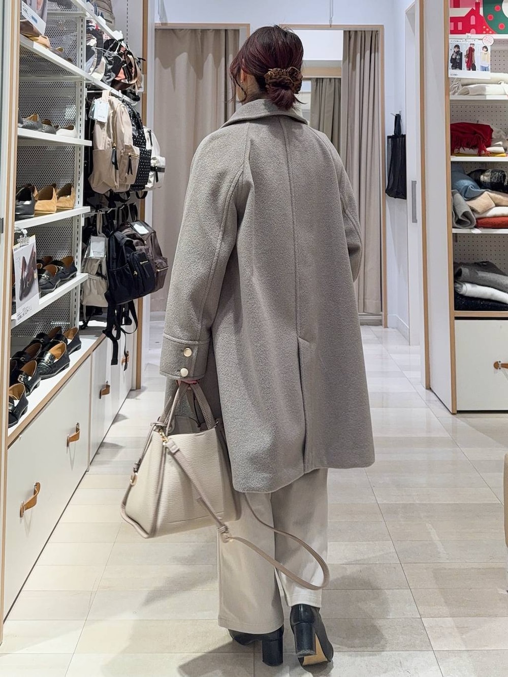 ベージュ系のチェスターコート、グレー系のその他パンツ、ベージュ系のトートバッグを着用したレディースの冬コーディネートの6枚目の写真