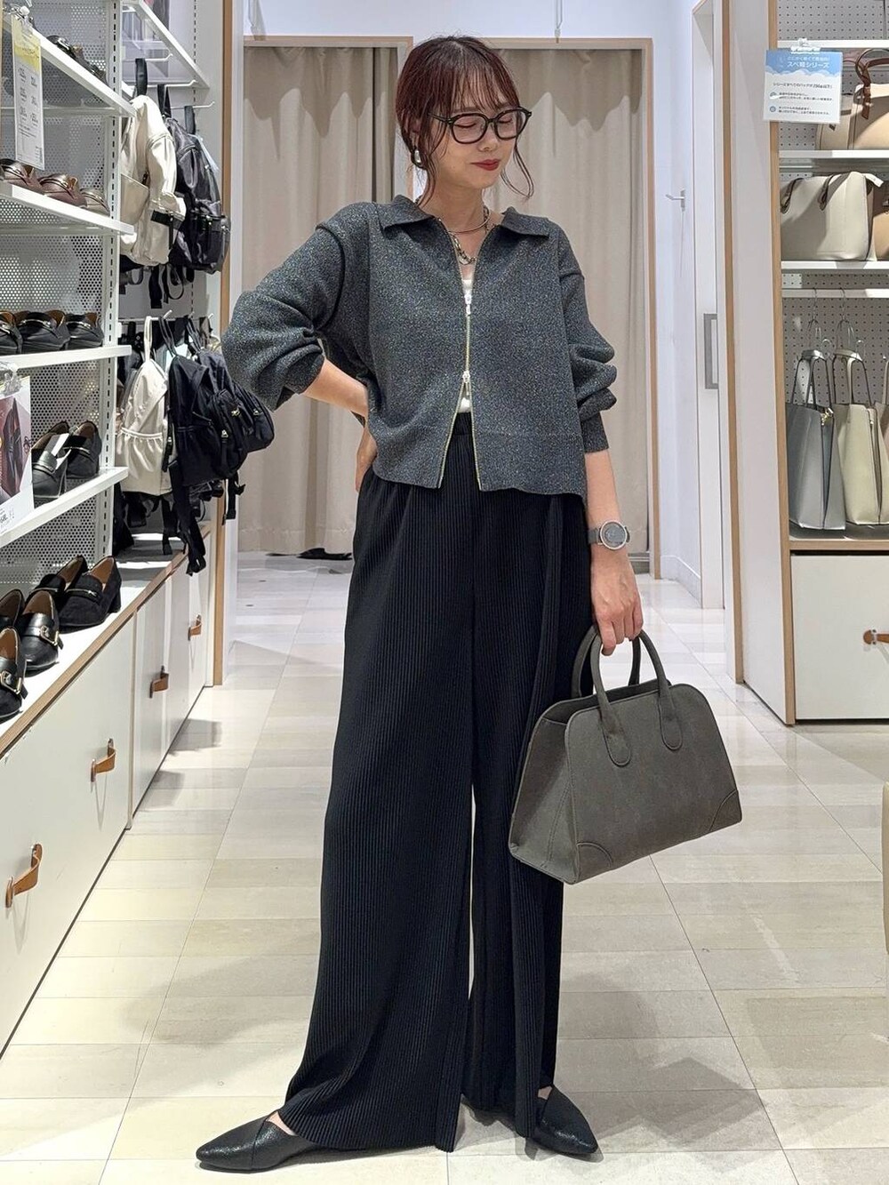 ブラック系のスニーカー、ブルー系のデニムジャケット、シルバー系のハンドバッグを着用したレディースの秋コーディネートの4枚目の写真