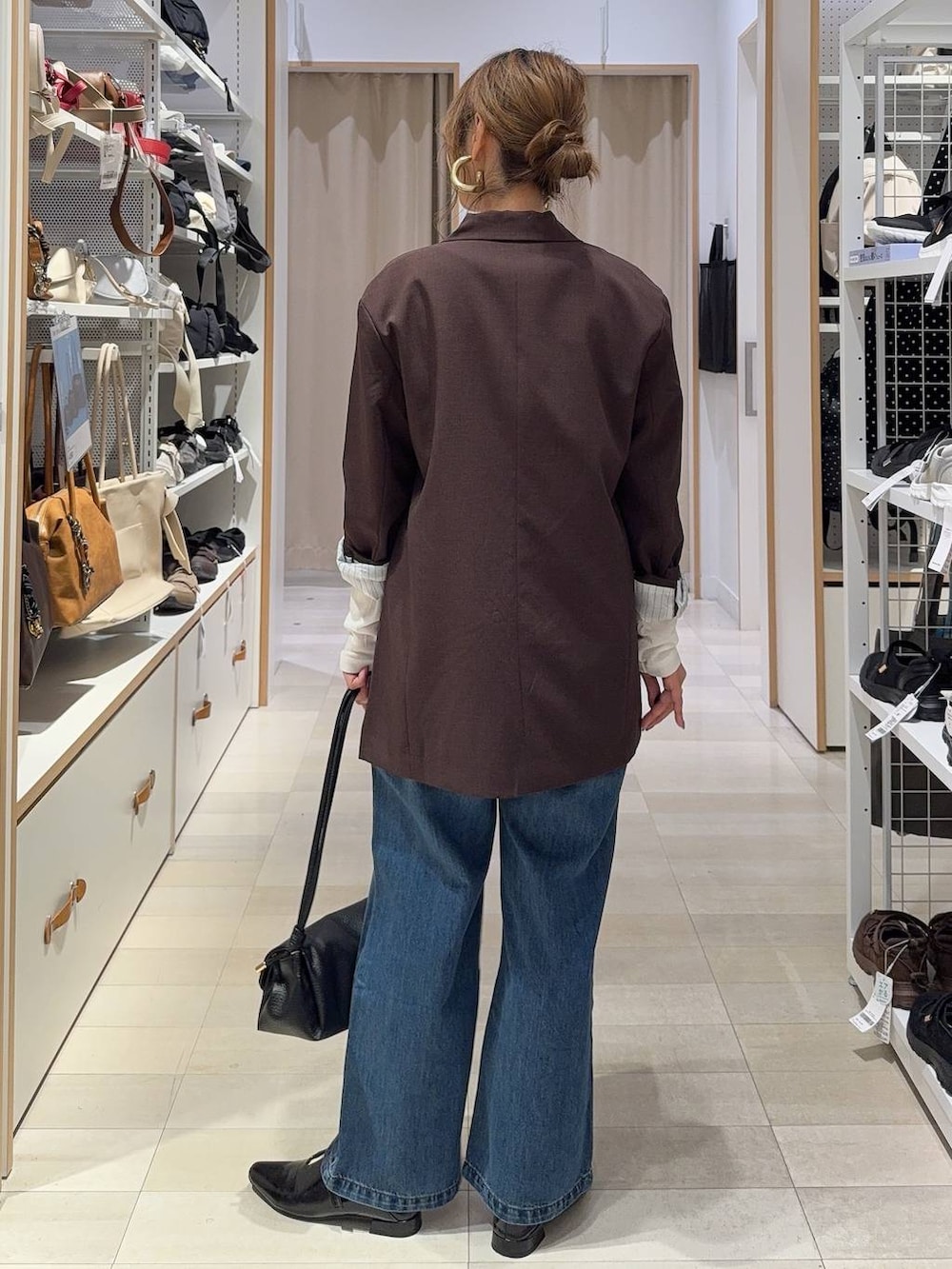 ホワイト系のTシャツ/カットソー、ブラック系のパンプス、ブルー系のデニムパンツを着用したレディースの秋コーディネートの5枚目の写真