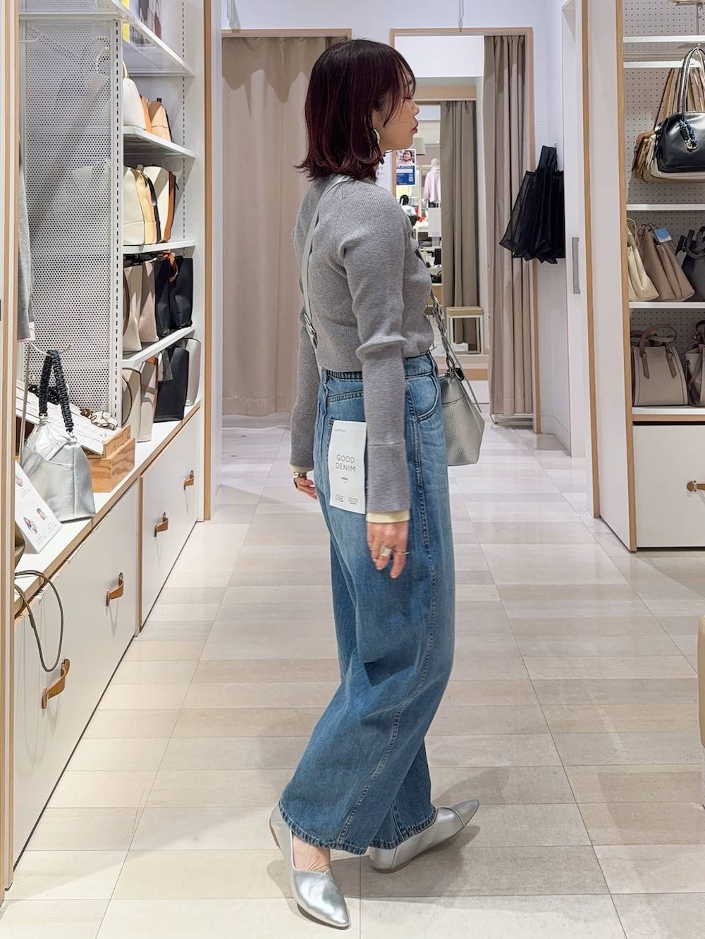 シルバー系のパンプス、ブラック系のその他アウター、ブルー系のデニムパンツを着用したレディースの冬コーディネートの8枚目の写真