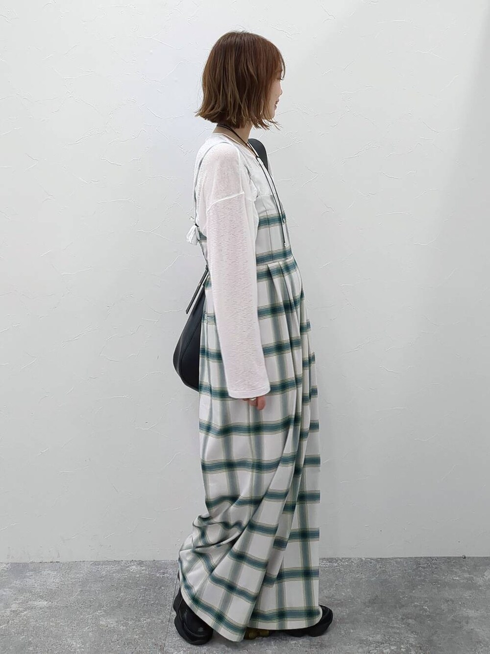 ホワイト系のTシャツ/カットソー、ブラック系のショルダーバッグ、ホワイト系のサロペット/オーバーオールを着用したレディースの春コーディネートの3枚目の写真