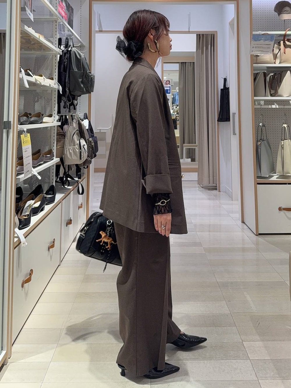 ブラック系のキャミソール、ブラウン系のテーラードジャケット、ブラウン系のスラックスを着用したレディースの秋コーディネートの4枚目の写真