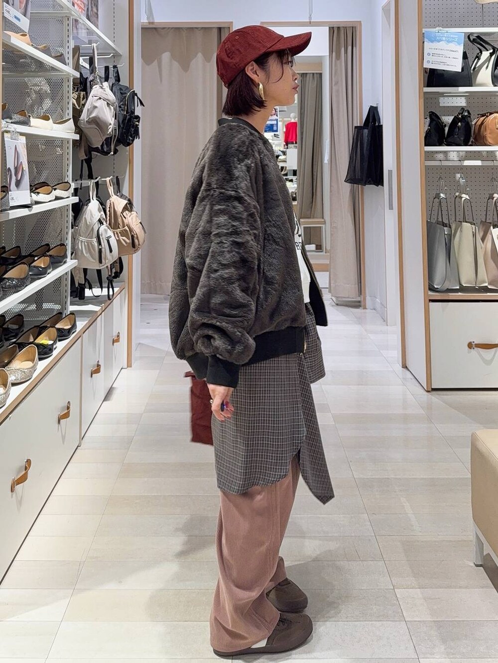 レッド系のトートバッグ、ブラック系のブルゾン、ピンク系のその他パンツを着用したレディースの秋コーディネートの4枚目の写真