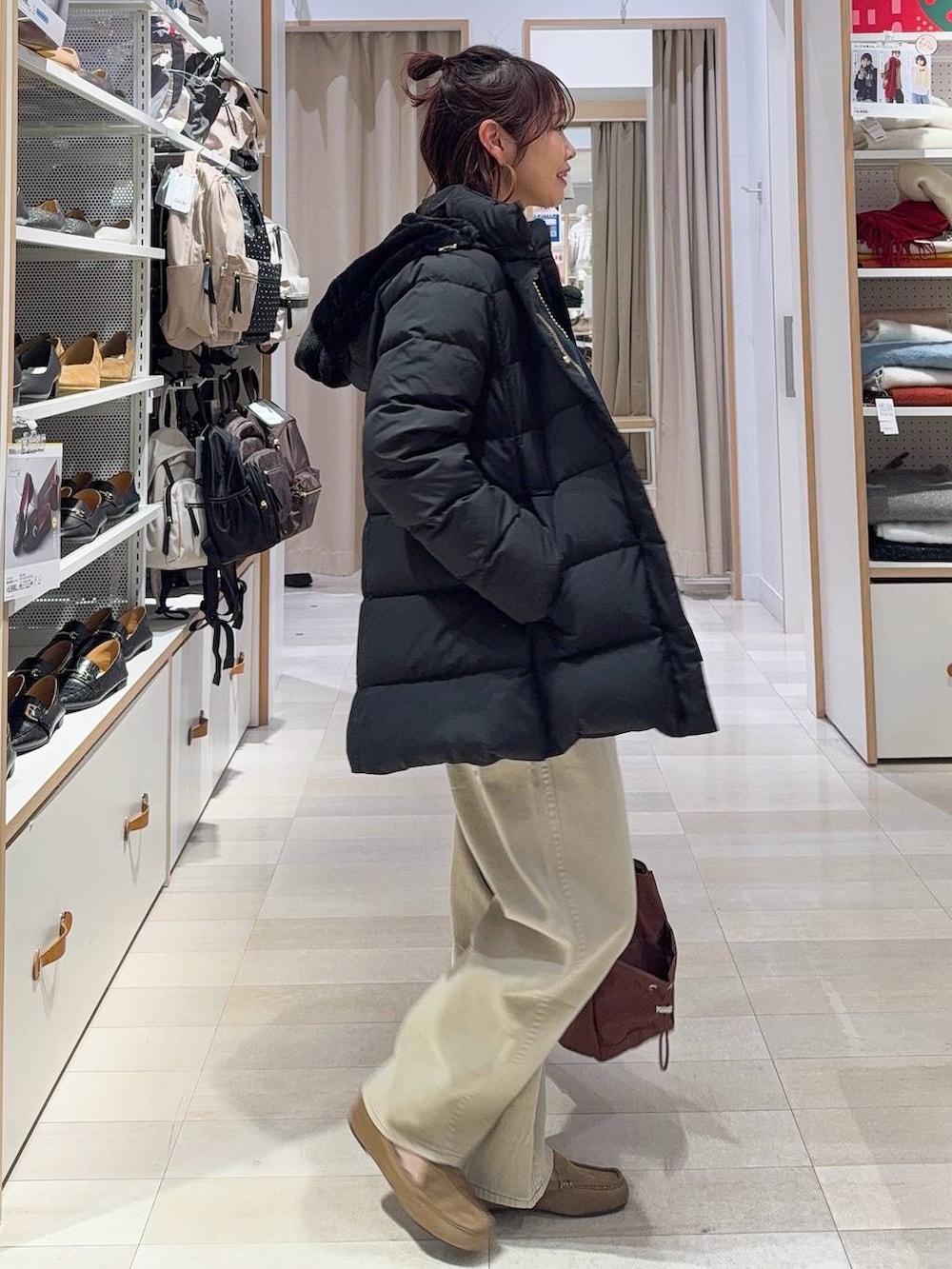 ブラック系のダウンジャケット/コート、ベージュ系のデニムパンツ、ホワイト系のTシャツ/カットソーを着用したレディースの冬コーディネートの4枚目の写真