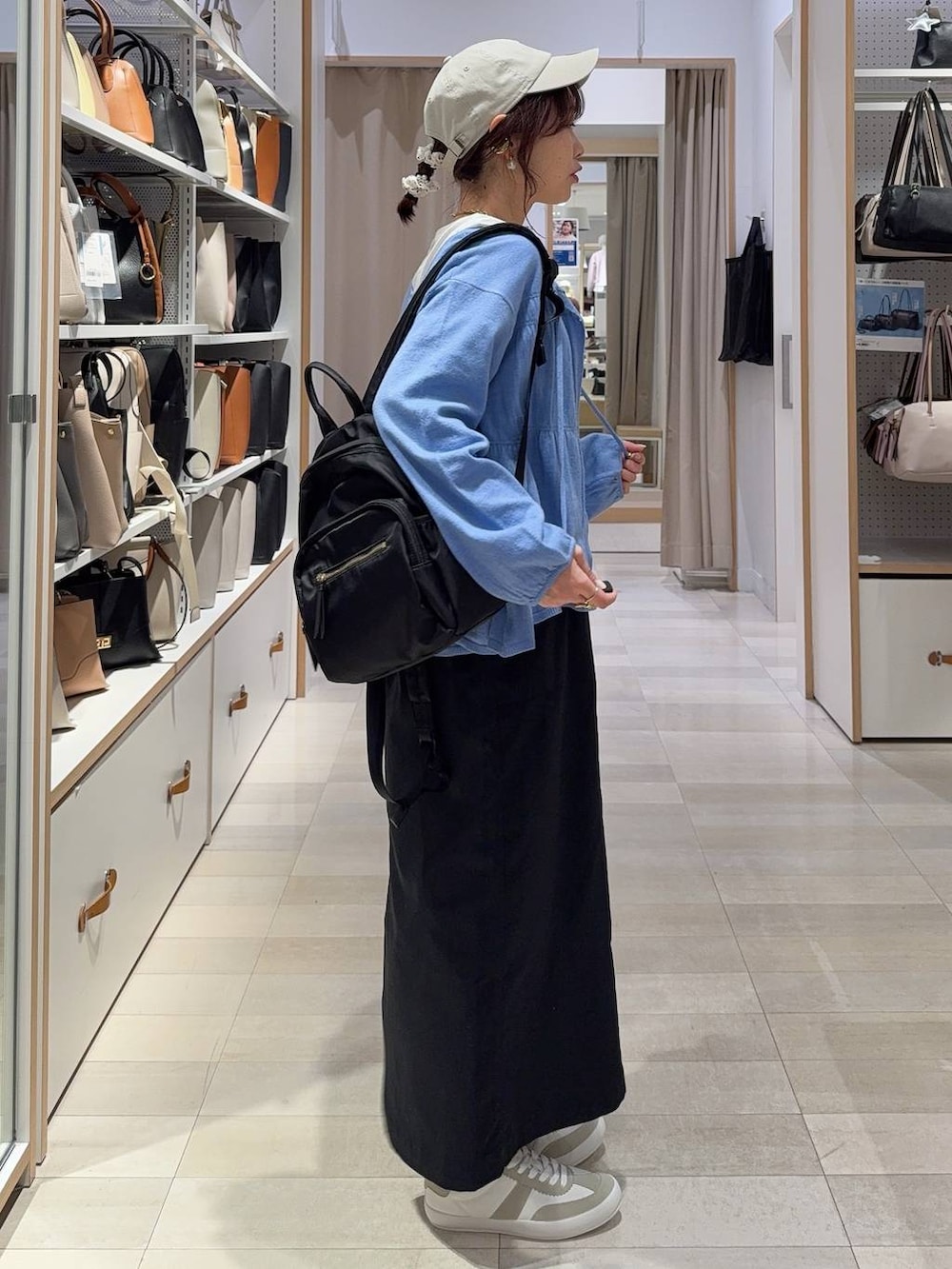 グレー系のスニーカー、ブラック系のバックパック/リュック、ブラック系のスカートを着用したレディースの春コーディネートの4枚目の写真