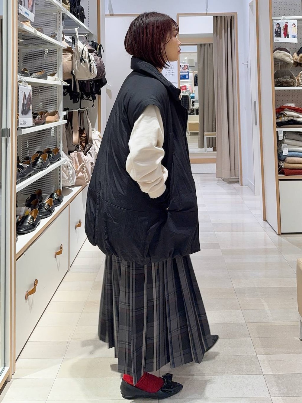 ブラック系のショルダーバッグ、ブラック系のニット/セーター、ブラック系のその他アウターを着用したレディースの秋コーディネートの6枚目の写真