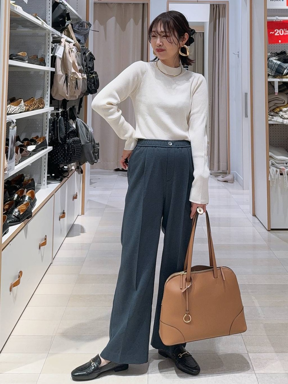 ブラック系のスニーカー、ブラック系のボストンバッグ、ホワイト系のニット/セーターを着用したレディースの冬コーディネートの2枚目の写真