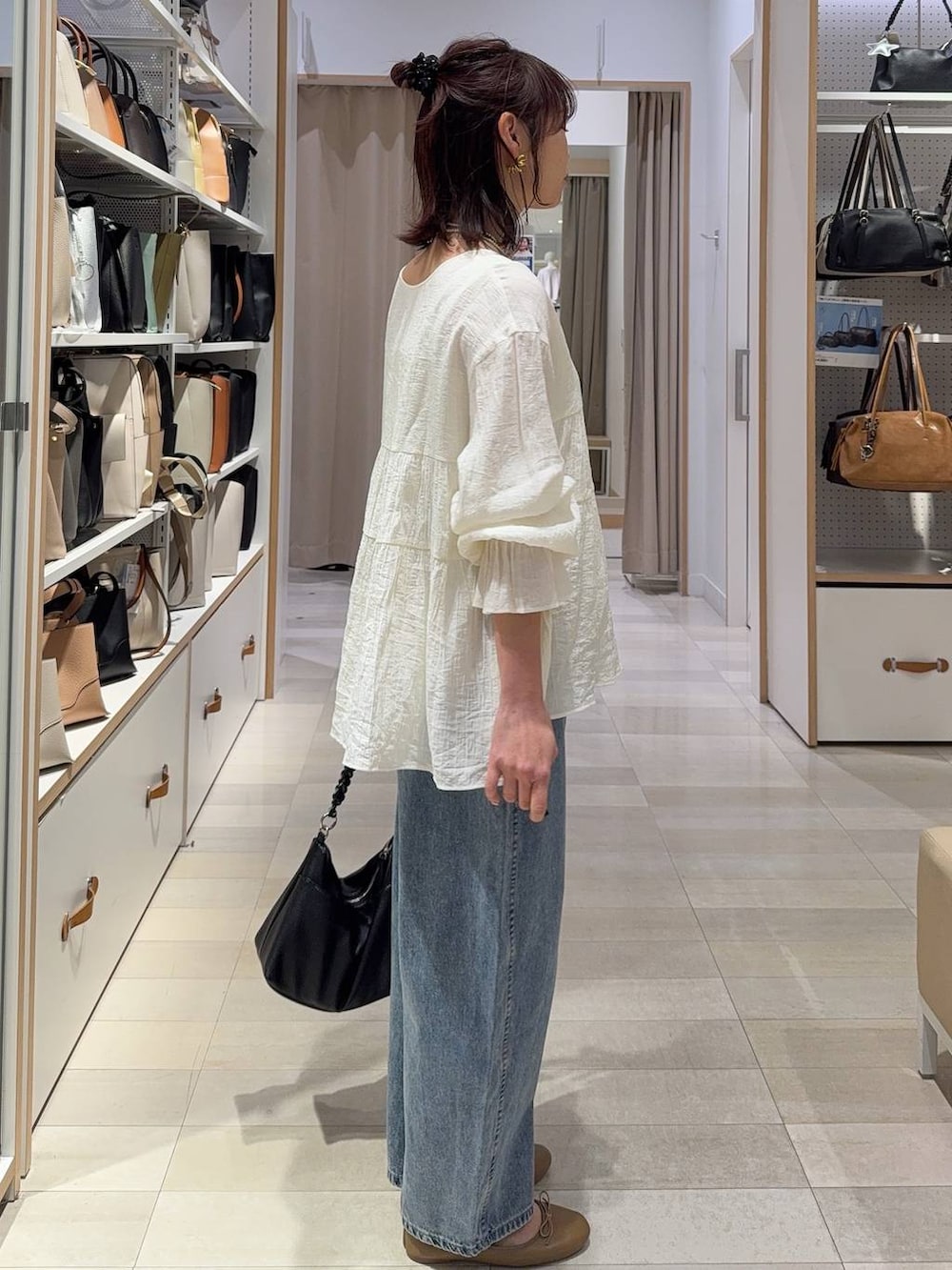 ブラック系のTシャツ/カットソー、ブラック系のスラックス、ブルー系のデニムパンツを着用したレディースの春コーディネートの8枚目の写真