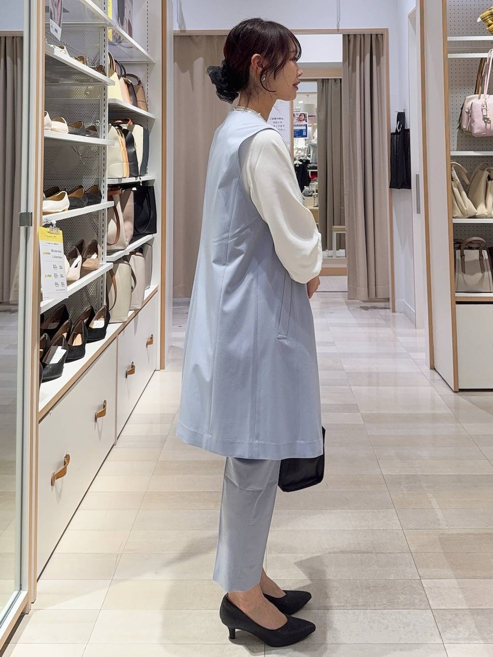 ブラック系のパンプス、ホワイト系のシャツ/ブラウス、ブルー系のスラックスを着用したレディースの冬コーディネートの5枚目の写真