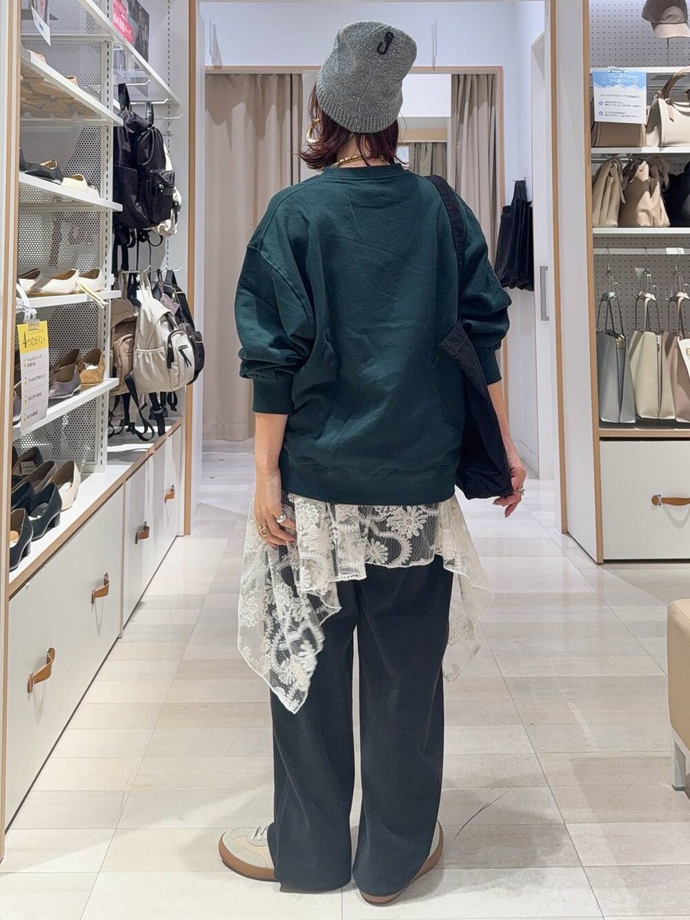 ベージュ系のスニーカー、グリーン系のスウェット、グレー系のトートバッグを着用したレディースの秋コーディネートの4枚目の写真