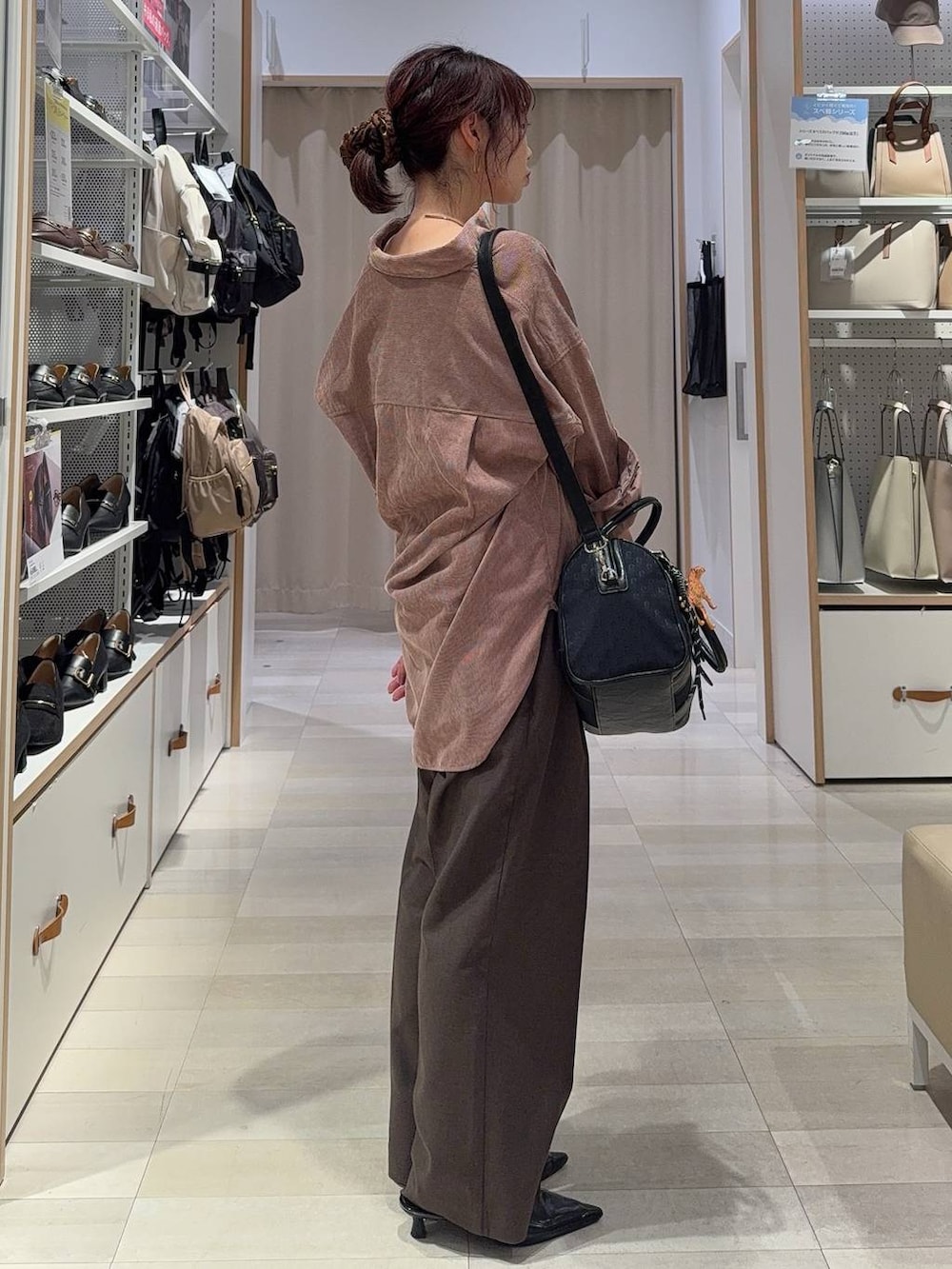 ブラック系のパンプス、ブラウン系のスラックス、ブラック系のボストンバッグを着用したレディースの秋コーディネートの8枚目の写真