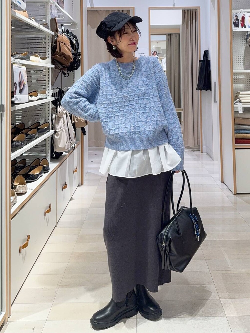 ブラック系のショルダーバッグ、シルバー系のパンプス、ブルー系のダウンジャケット/コートを着用したレディースの秋コーディネートの3枚目の写真