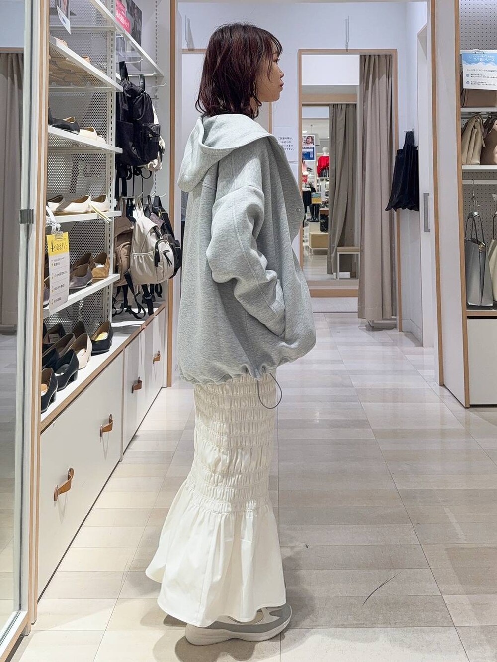 ホワイト系のスニーカー、ブラック系のキャミソール、ブラック系のハンドバッグを着用したレディースの秋コーディネートの4枚目の写真